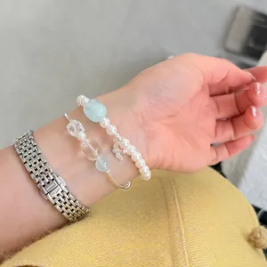 Primer plano de elegantes pulseras de cuentas con tubos de plata en la muñeca