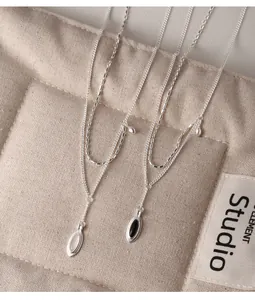 Detail view of 925 sterling silver double-layered necklaces with black and white pendants