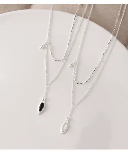 Close-up detail of 925 sterling silver layered necklace with black agate and white chalcedony