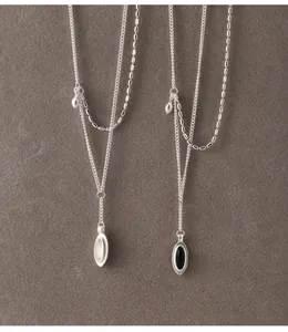 Close-up of 925 silver necklaces with oval black onyx and white chalcedony pendants