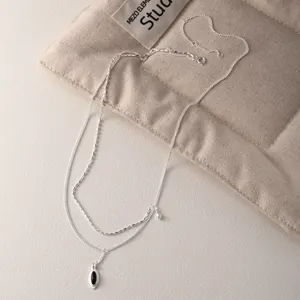 925 sterling silver double-layered necklace with oval black onyx pendant on beige fabric