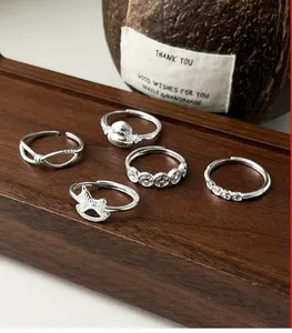 Detailed view of 999 sterling silver adjustable ring set with coin and gourd charms