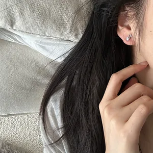 Close-up detail of s925 sterling silver tulip stud earring worn on ear by woman