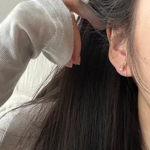 Close-up of a pink tulip stud earring in S925 sterling silver worn on a woman's ear.