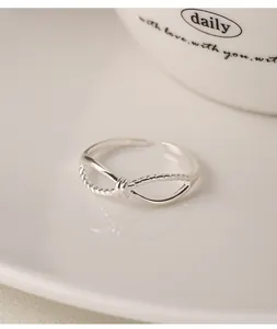 Close-up view of a minimalist 999 sterling silver infinity knot ring with rope detail