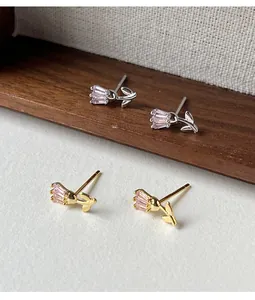 Detailed close-up of gold and silver tulip stud earrings featuring elegant pink crystal petals