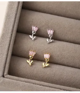 Detailed close-up of dainty pink tulip sterling silver earrings in gold and silver finishes