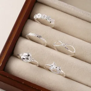 Elegant S999 silver ring set with coin, heart, and bow designs in jewelry box