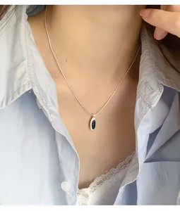 Detailed view of S925 sterling silver oval black onyx pendant on minimalist snake chain