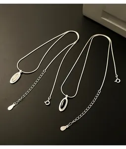 Macro detail of S925 silver snake chain necklaces featuring oval onyx and white chalcedony.
