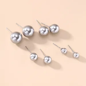Set of four pairs of elegant gray round pearl stud earrings in various sizes for women.