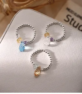 Detailed close-up of handmade 925 sterling silver beaded rings with colorful crystal charms