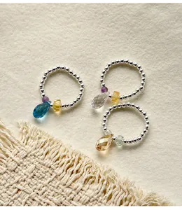 Detail view of 925 sterling silver beaded rings with teardrop crystal charms.