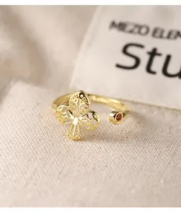 Detailed view of irregular gold clover ring with red zircon inlay on S925 silver band.