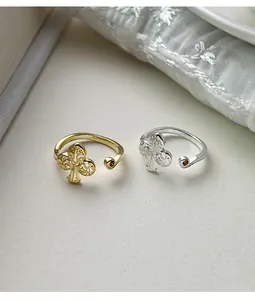 Close-up of gold and silver 925 sterling silver open rings with hollowed floral motif