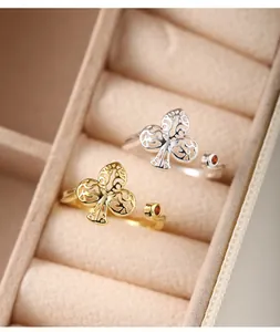 Detailed view of gold and silver plum blossom rings with zircon in a jewelry box