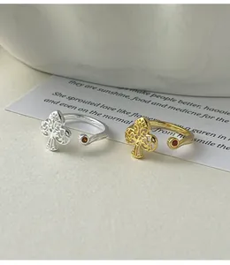 Close-up detail of 925 sterling silver hollow clover ring with red zircon stone