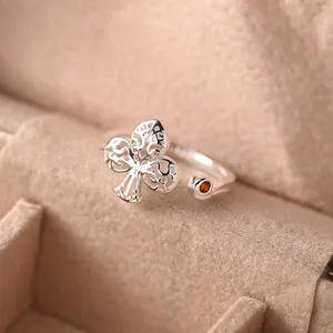 Elegant 925 sterling silver trefoil ring with zircon in a beige velvet jewelry box.