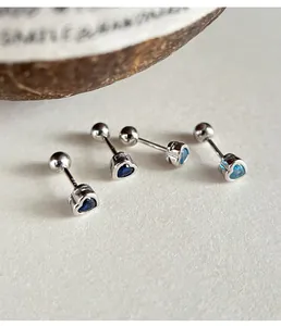 Macro view of small blue heart zircon stud earrings with 925 silver screw back balls