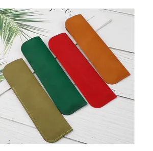 Detailed view of four colorful retro PU leather pen sleeves on a white wooden background