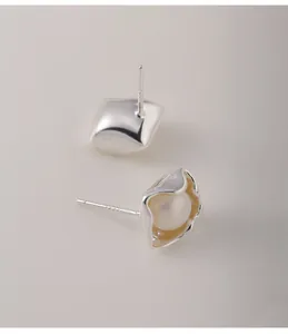 Close-up of irregular 925 sterling silver square stud earrings with pearl inlay