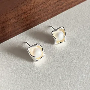 925 sterling silver irregular square stud earrings with pearl on a textured background