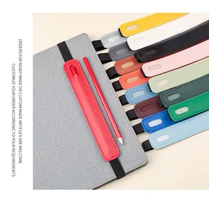 Detailed macro view showing various colors of PU leather elastic pen holders on notebook