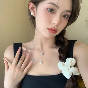 Close-up of elegant 925 silver bowknot necklace with hanging pearl on Asian model