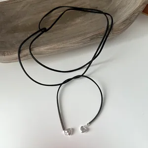 Detail of long black cord necklace with s925 silver heart pendants for women