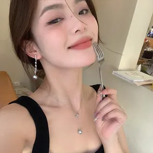 Elegant 925 silver necklace with bow and pearl detail shown on a model.
