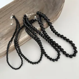 Close-up of three different sizes of black agate beaded necklaces with silver clasps