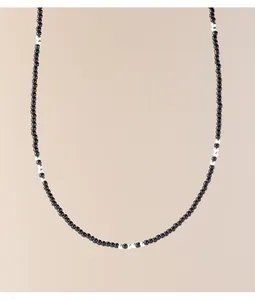Primo piano di una delicata collana di perline nere e argento fatta a mano per layering.