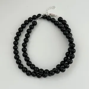 Detailed view of polished black onyx beads and s925 sterling silver clasp.