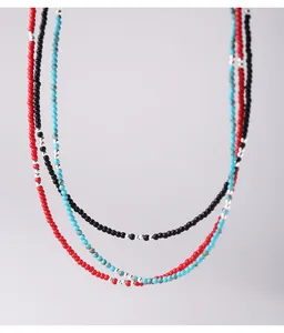 Primo piano di collane di perle fatte a mano con piccole perline d'argento.