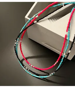 Primo piano di collane di perline di riso in argento s925 fatte a mano su base grigia.