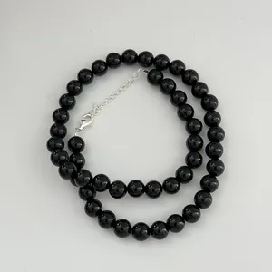 Detail of black onyx bead necklace featuring a polished S925 sterling silver clasp.