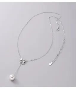 Detailed macro view of S925 sterling silver bow pendant with shimmering white pearl drop