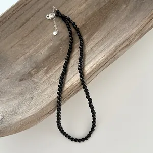 Close-up of minimalist black onyx bead necklace with S925 sterling silver clasp