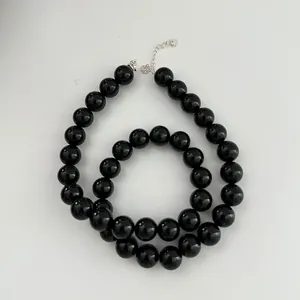 Detailed macro view of polished black agate beads on a S925 sterling silver chain