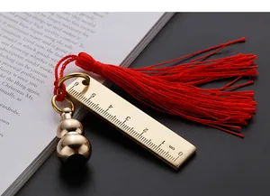 Close-up of 6cm brass ruler keychain with gourd pendant and red tassel detail.