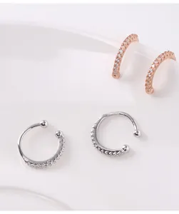 Detailed view of silver and rose gold diamond-set hoop ear cuffs for non-pierced ears