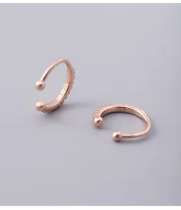 Close-up of 925 sterling silver diamond-encrusted ear cuff with minimalist rose gold finish
