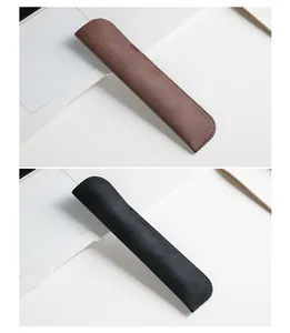 Dettaglio di astucci per penne in pelle marrone e nero minimalisti su scrivania