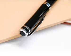 Macro view of a professional black and silver metal rollerball pen on a notebook.