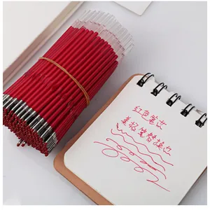 Detail view of red gel pen refills with a writing sample on a paper notebook