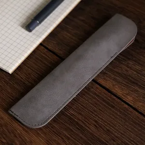 Custodia minimalista in pelle grigia per penna stilografica singola su scrivania in legno