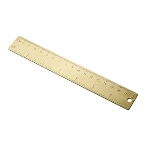 Regla vintage de latón de 18 cm con doble escala (cm/pulgadas) sobre fondo blanco