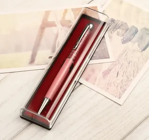 Dettaglio di una penna a sfera in cristallo rosa in una confezione regalo trasparente.