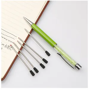 Detailed view of 0.5mm metal pen refills shown with a green crystal ballpoint pen