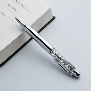 Detailed view of elegant silver ballpoint pen with sparkling crystal filled barrel